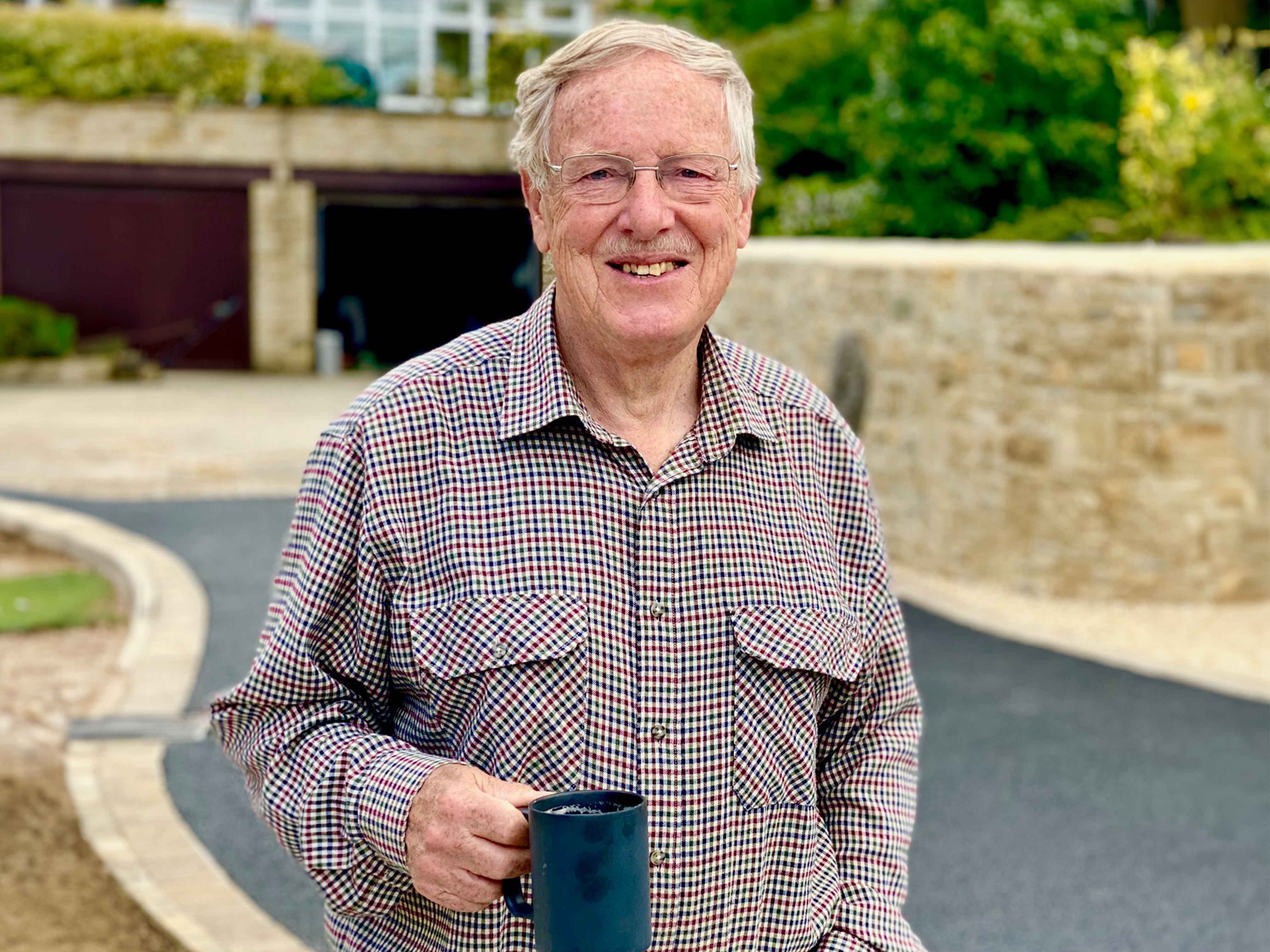 A man simling in-front of his new driveway